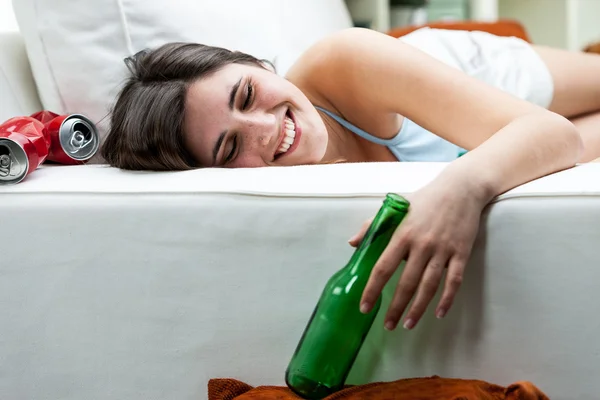 Happy drunk young woman relaxing on a sofa — Stock Photo, Image