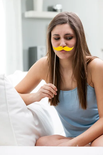 Young woman posing with a yellow mustache — Stock Photo, Image