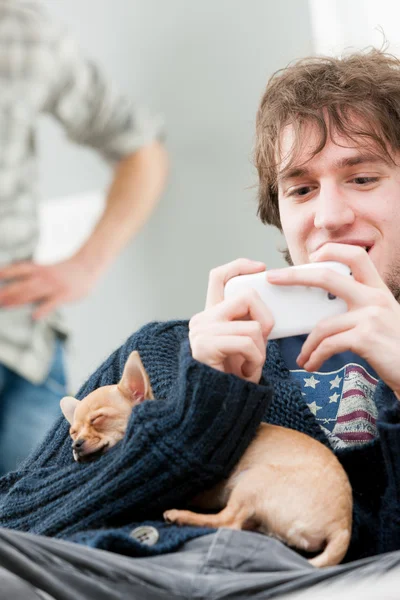 Junger Mann trägt blauen Pullover mit Handy — Stockfoto