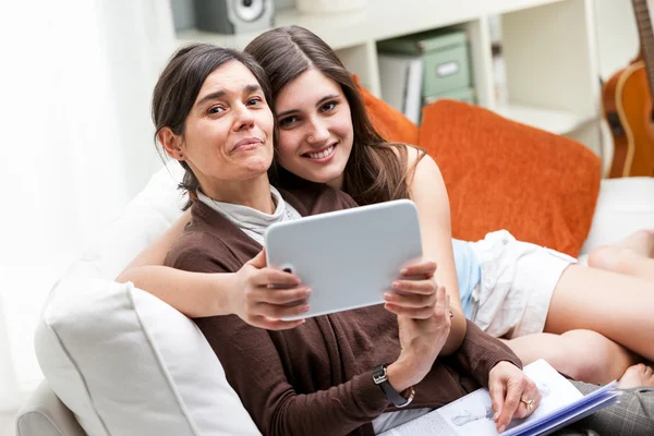 Mãe feliz usando tablet computador com filha — Fotografia de Stock