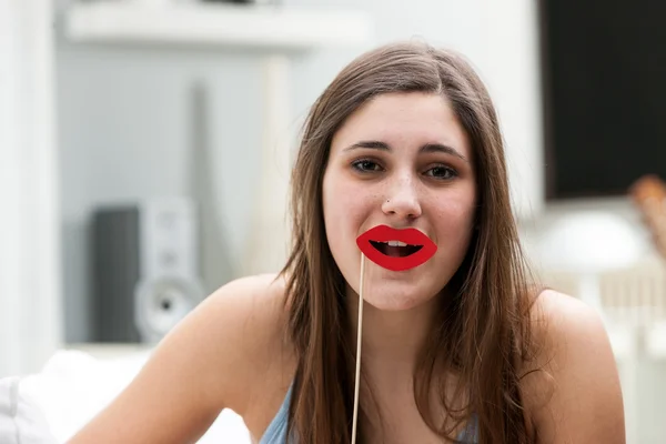 口の近くの唇支柱を保持している遊び心のある女性 — ストック写真