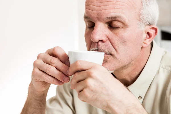 Nöjd man smuttar från tea cup — Stockfoto