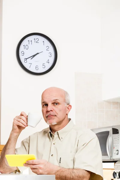 Schöner bärtiger älterer Mann am Tisch mit Uhr — Stockfoto