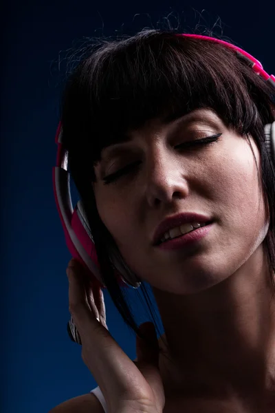 Žena se zavřenýma očima a s úsměvem pomocí sluchátek — Stock fotografie