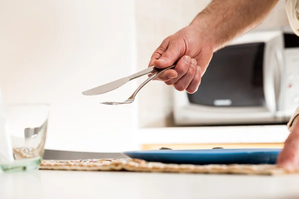 Close up of hand holding fork and knife at table — Stock Photo, Image