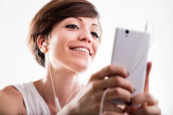 Kvinna som lyssnar på musik på sin mobiltelefon — Stockfoto