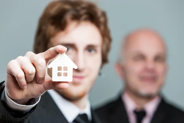 Close up on little house symbol held by man — Stock Photo, Image