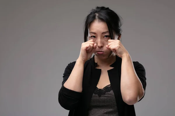 Расстроенная Угрюмая Азиатка Плачущая Поднимая Руки Глазам Печали Серого Фона — стоковое фото