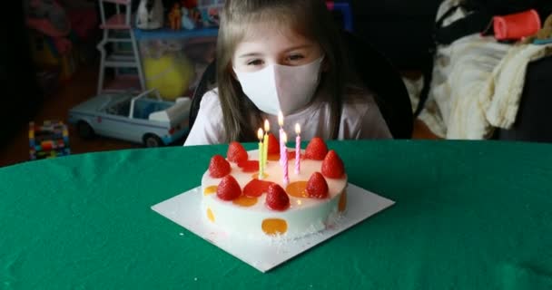 Niña frustrada tratando de soplar velas de cumpleaños con una máscara — Vídeo de stock
