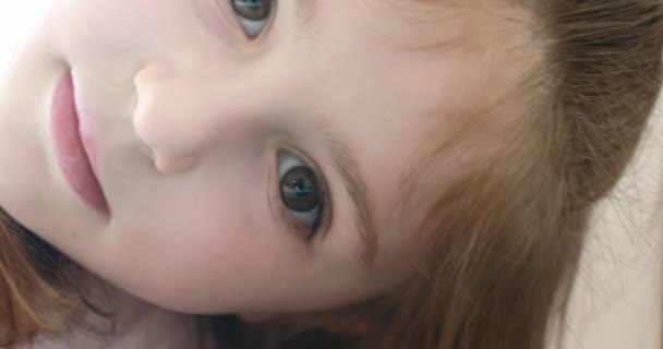 Маленькая девочка строит рожи перед камерой — стоковое видео