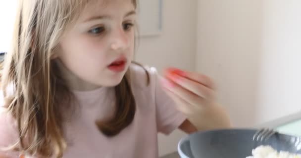Κορίτσι και αστεία πρόσωπα και φράουλες κέικ στην κουζίνα — Αρχείο Βίντεο