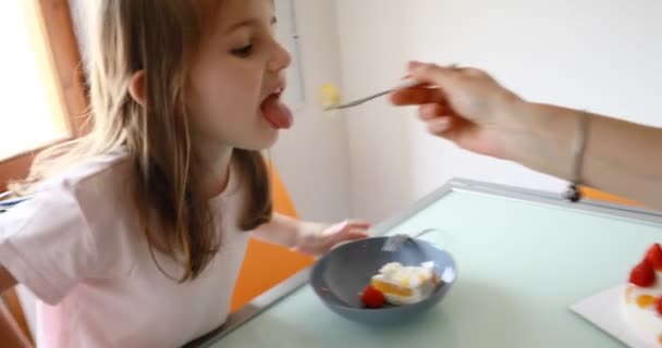 Flicka och roliga ansikten och jordgubbstårta i köket — Stockvideo
