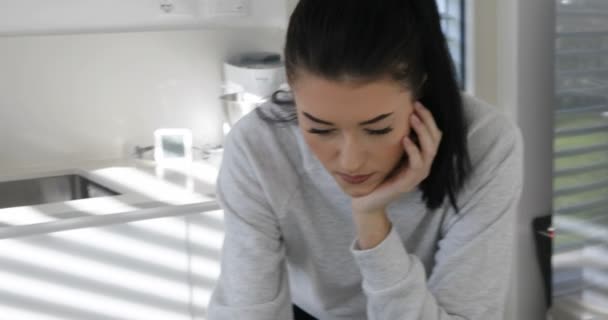 Mladá žena z kuchyně na pohovku s chytrým telefonem — Stock video