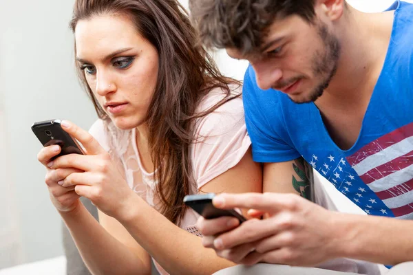 Pareja Joven Absorta Uso Sus Teléfonos Móviles Mientras Sientan Lado — Foto de Stock