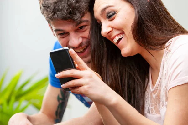 Pareja Joven Riendo Felizmente Juntos Mientras Ven Los Medios Juntos —  Fotos de Stock