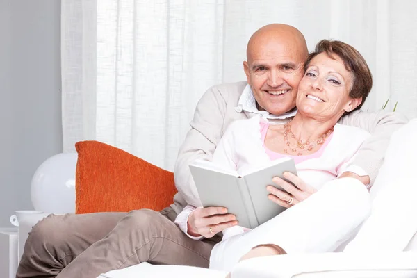 Happy Couple Relaxing Sofa Together Reading Book Smiling Wife Reclining — Stock Photo, Image