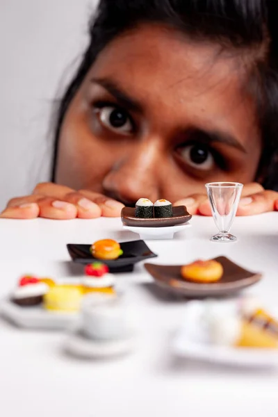 Confused Young Woman Eyeing Healthy Unhealthy Food Seafood Sushi Pastries — Stock Photo, Image