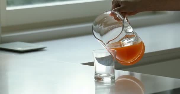 Apelsinjuice hälls från en kanna i ett glas — Stockvideo