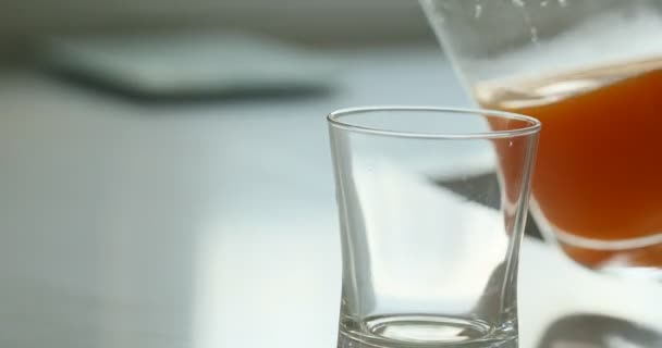 Orangensaft wird aus einem Krug in ein Glas püriert — Stockvideo