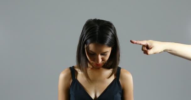 Een beschuldigende hand wijst naar het gezicht van een vrouw, vernedert haar — Stockvideo