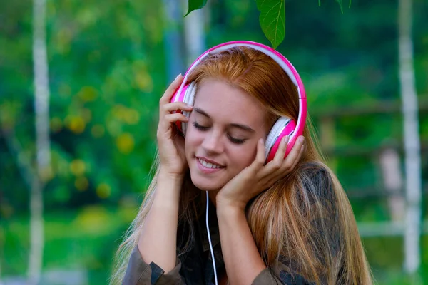 Young Woman Listening Music Headphones Sitting Bench Public Park Nature — Fotografia de Stock