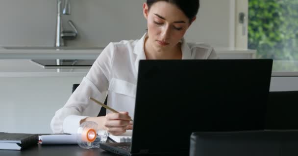 Chica estudia y dibuja con teléfono inteligente y portátil — Vídeo de stock