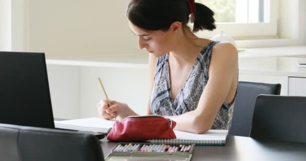 Cute minute girl works or studies with computer and pencil — Stock Video