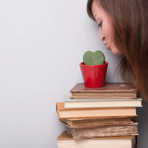 Bella ragazza amando la sua pianta e i suoi libri — Foto Stock