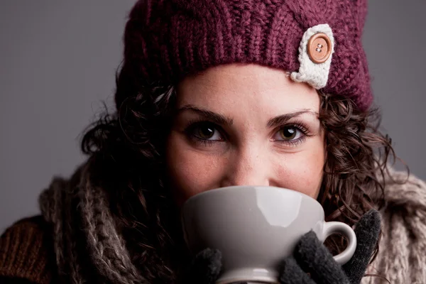 Young woman drinks something hot — Stock Photo, Image