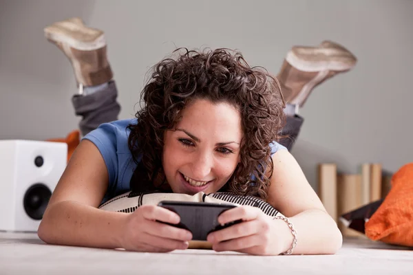 Girl playing videgames on her mobile phone — Stock Photo, Image