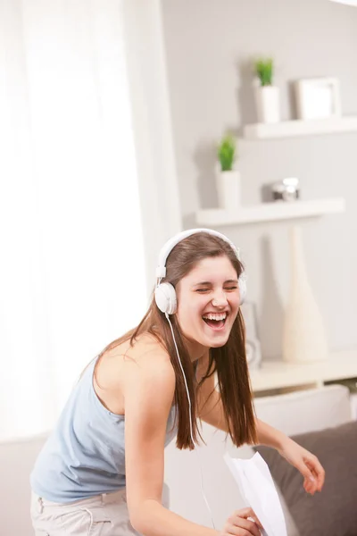 Meisje zingen en lachen in haar woonkamer — Stockfoto