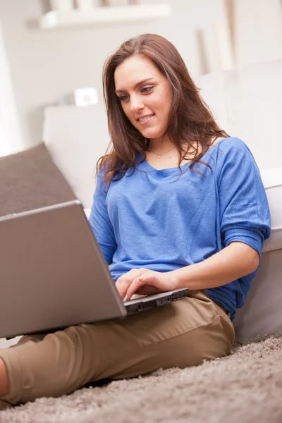 Junge Frau mit ihrem Notizbuch im Wohnzimmer — Stockfoto