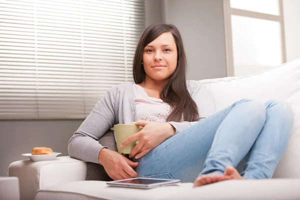 Nyugodt nő reggeli elfogyasztására a nappaliban — Stock Fotó