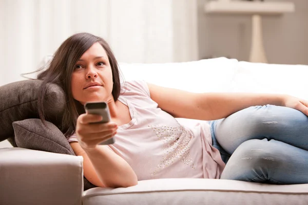 Menina mudando programa em sua televisão — Fotografia de Stock