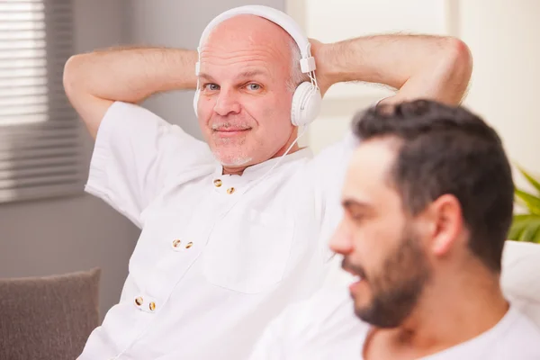 Homme souriant en écoutant de la musique — Photo