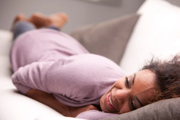 Schöne afrikanisch-amerikanische Frau auf einem Sofa liegend — Stockfoto