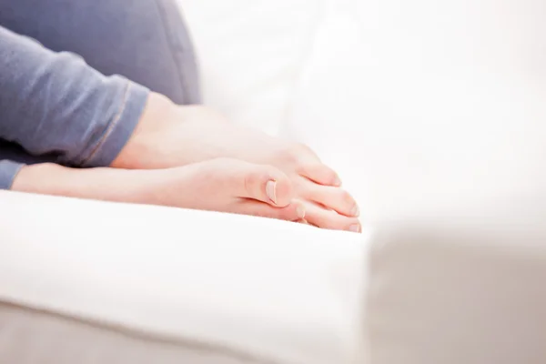 Pieds d'une jeune femme dormant sur un canapé — Photo