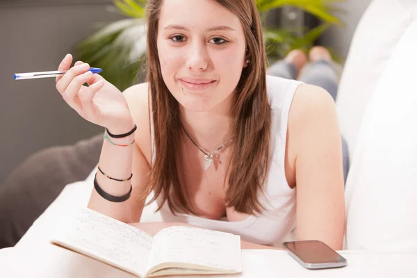 Girl studying on a sofa — Stock Photo, Image