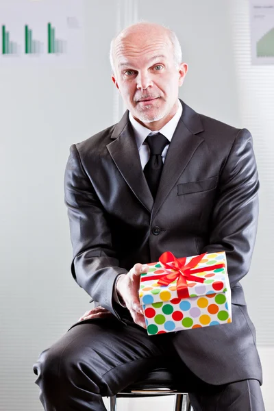 Podnikatel s dárkem ve svých rukou — Stock fotografie