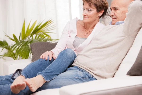 Mature couple watching tv on the sofa — Stock Photo, Image