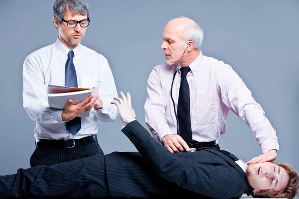 Clerks repairing a businessman for fun — Stock Photo, Image