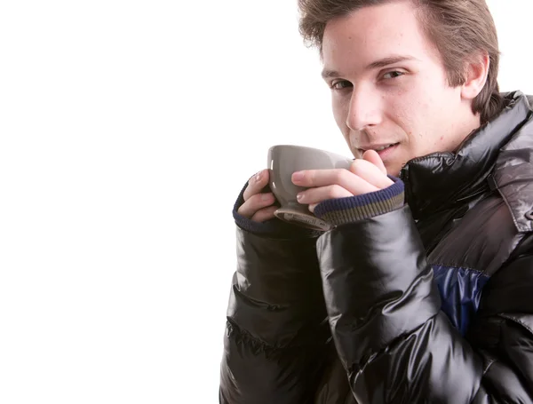 Young man having a hot drink in winter — Stock Photo, Image