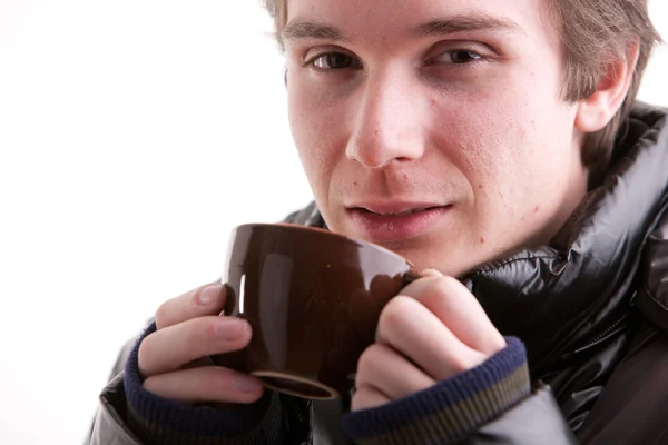 Jeune homme prenant une boisson chaude en hiver — Photo