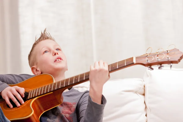 Liten pojke spelar gitarr hemma — Stockfoto