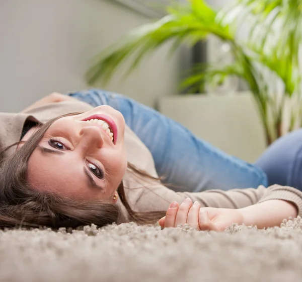 Vrouw lachen ondersteboven op verdieping — Stockfoto