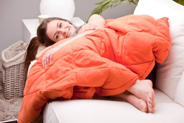 Young sexy woman smiling on a couch — Stock Photo, Image