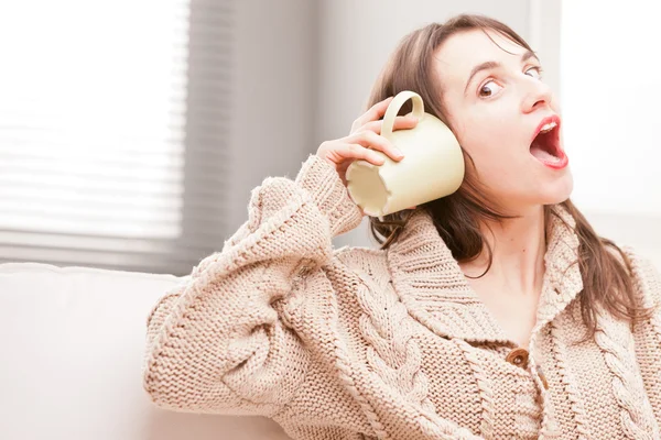 Menina ouvindo caneca — Fotografia de Stock