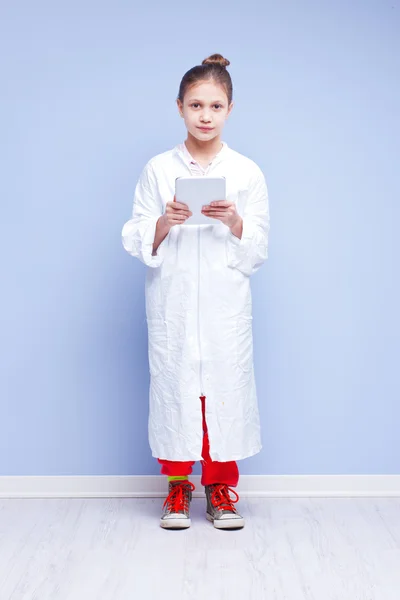 Little scientist girl in a smock with a digital tablet — Stock Photo, Image