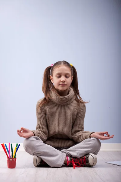 Liten flicka meditera istället för att göra läxor — Stockfoto