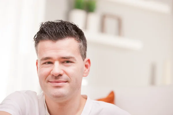 Man smiling to camera relaxing in his living room — Stock Photo, Image